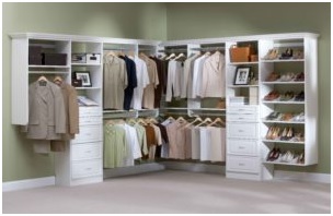 Walk-in closet with green walls and white custom shelving and hangers, and white carpet.